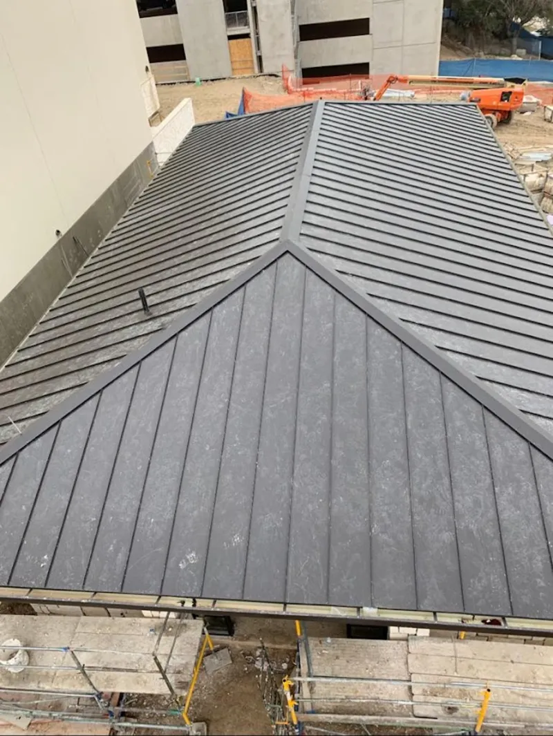 Commercial metal roof construction with crane equipment in Mill Creek East